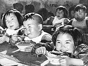 Crianças comendo em uma creche em uma comuna popular