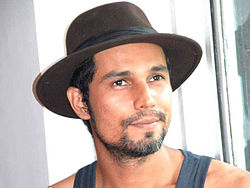 Hooda wearing a hat looking into the camera