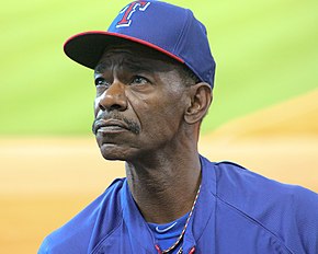 A man wearing a blue baseball jersey and cap