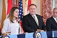 Freeland speaks at a 2018 press conference as Mike Pompeo and Jim Mattis look on.