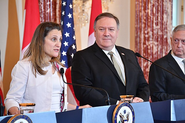 Freeland speaks at a 2018 press conference as Mike Pompeo and Jim Mattis look on.
