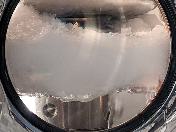 A layer of solid xenon floating on top of liquid xenon inside a high voltage apparatus