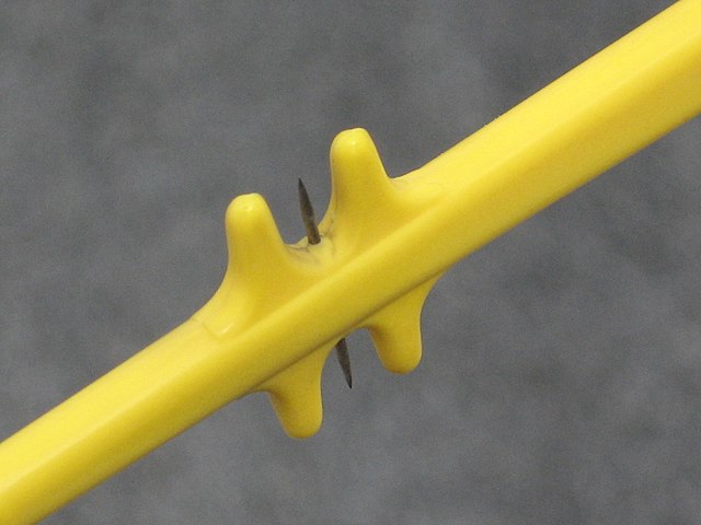 A portion of a static discharger on an aircraft. Note the two sharp 3/8" metal micropoints and the protective yellow plastic.