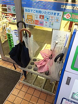 Umbrella holder outside a store Umbrella holder outside convenience store (14232292011).jpg