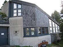 Ein Gebäude mit Holzschindeln, Mauer und Fenster. Das Forschungslabor des Alpengartens am Patscherkofel.