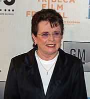 A brown haired women in a black jacket and white shirt