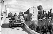 German Panzer III tanks advance through a Tunisian town Bundesarchiv Bild 101I-049-0008-33, Nordafrika, Panzer III bei Fluss-Uberquerung.jpg