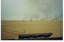 A United States Marine Corps tank bears witness to burning Iraqi tanks and Iraqi soldiers leaving their fighting positions at a battle that took place at Burgan Oil Field during the 1st Gulf War, February 1991. Burgantankbattle.jpg