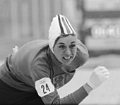 Eine Frau im Eislaufgewand, in einer Wettkampfhaltung