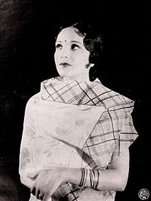 A black-and-white portrait of a woman smiling at the camera