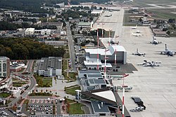 Luchtfoto van Ramstein met hangars, magazijnen en de passagiersterminal naast de vluchtlijn.