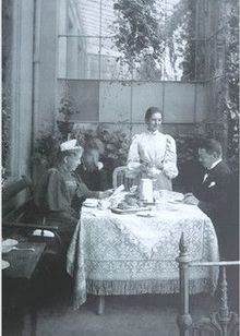 Familie Becker, Vater Carl Woldemar Becker (links, hinten) und Mathilde Becker, geborene von Bültzingslöwen (links, im Vordergrund sitzend), Paula Becker (stehend, Bildmitte in einem hellen Reformkleid) im Wintergarten in der Schwachhauser Chaussee 23