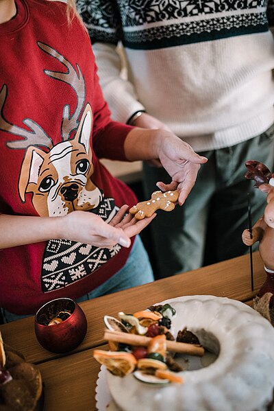 File:Girl in Christmas sweater holding Christmas gingerbread man cookie (49134188886).jpg