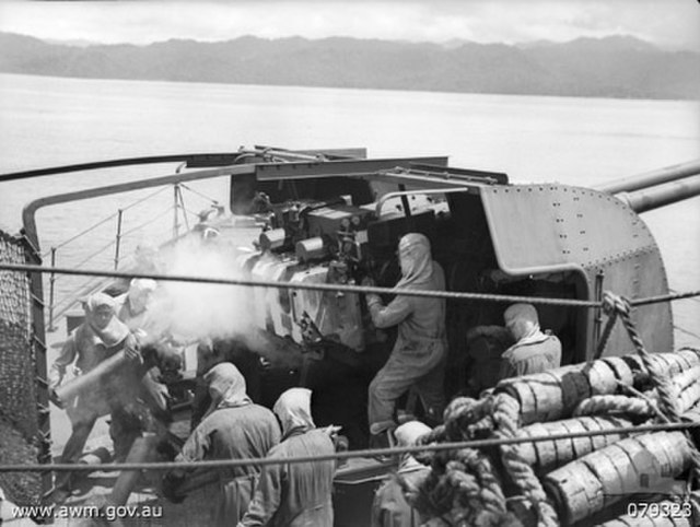 Twin guns of HMAS Swan bombarding shore positions in New Guinea, February 1945