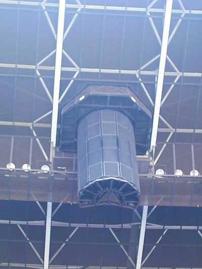 A speaker array mounted in the rafters in a camp sports facility.