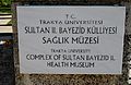 لوحة كتب عليها عبارة متحف مجمع السلطان بايزيد الصحي-جامعة تراكيا- باللغة التركية والإنجليزية