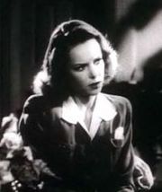 Photographie en noir et blanc d'une jeune femme aux cheveux bouclés.