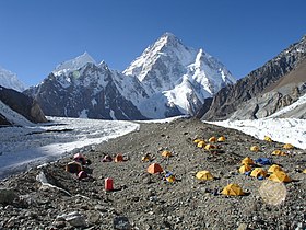 Vue du camp de base du Broad Peak installé sur la moraine centrale du glacier Godwin-Austen, avec le K2 en arrière-plan.