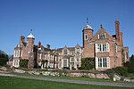 Kentwell Hall including detached building to the west, brick revetment of moat and two bridges over moat. Kentwell 01.jpg