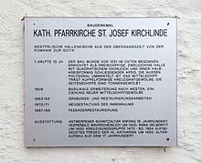 Information board, as can be found on some of Dortmund's architectural monuments.  Rectangular metal plate on white wall.  Engraved on it in black capital letters: “Catholic.  Parish church St. Josef Kirchlinde ”, above a small“ monument ”, below it a brief description of the church, below it a brief overview of the structure, including information about the equipment.