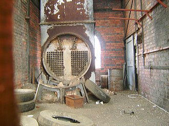 Additional waste heat boiler (partially dismantled) in the rear room of the Vertical Retort Building. Note the insulated co2 flue connecting the boiler to the retort blocks. Launceston Gas Works Boiler in the Vertical Retort.jpg