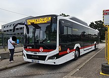 Photographie couleur d'un bus à l'arrêt numéroté 52 et en direction de Vaulx-en-Velin.