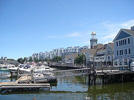 Looking east-southeast toward the boardwalk, clock tower and shops at Marina Bay in Quincy, Massachusetts, with the Marina Point condominiums in the background. Marina Bay Quincy 2009.jpg