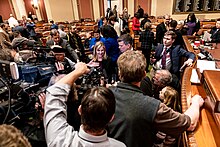 Hortman on the House Floor surrounded by reporters