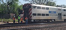 Workers cutting off the plow of Cab Car 8473 after hitting a truck Metra Cab Car 8473 Being Worked on after the Train hit a Truck.jpg