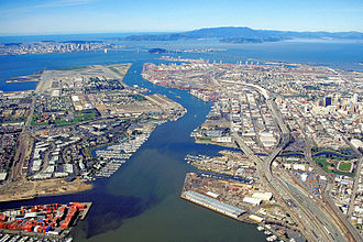 The runways and remainder of the Alameda Naval Air Station can be seen at the end of Alameda Island in this aerial view of the port of Oakland, California. Oakland California aerial view.jpg