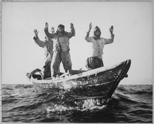 Three North Koreans surrender to USS Manchester by raising their arms Three Korean Communists in a fishing boat are captured by the USS Manchester off the coast of Korea. - NARA - 520792.tif