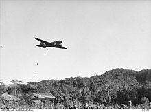 Dropping food supplies on a cleared space at Nauro village during the advance of the 25th Infantry Brigade over the Owen Stanley Range Transport plane drops supplies near Nauro.jpg