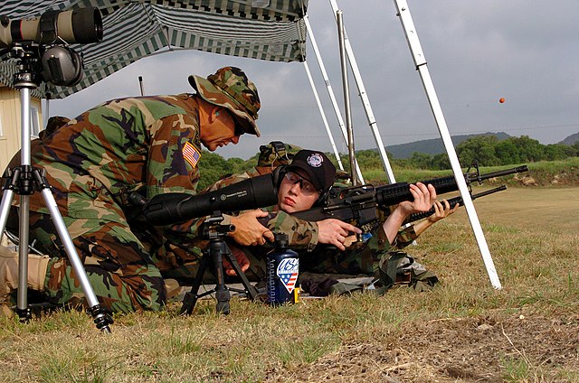 U.S. Army Reserve Sgt. Maj., left, instructs U.S. Navy Midshipman on proper body positioning during live-fire marksmanship training in June 2005