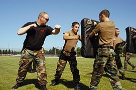 US Navy 080716-N-4386D-001 Master-at-Arms 1st Class Doug Terou, left, assigned to Naval Station Everett, Wash., encourages members of the U.S. Naval Sea Cadet Corps to work during a master-at-arms training exercise.jpg