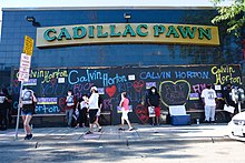 Protesters at the boarded-up Cadillac Pawn shop in Minneapolis, July 21, 2020. Vigil for Calvin Horton at Cadillac Pawn (50140695201).jpg