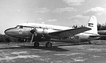 photographie en noir et blanc montrant de côté un avion bimoteur stationné sur un aéroport
