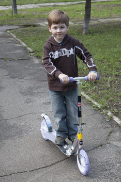 Young dzhydi riding a scooter outside