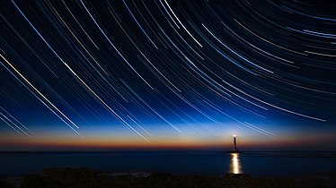 Star trails above lighthouse, France