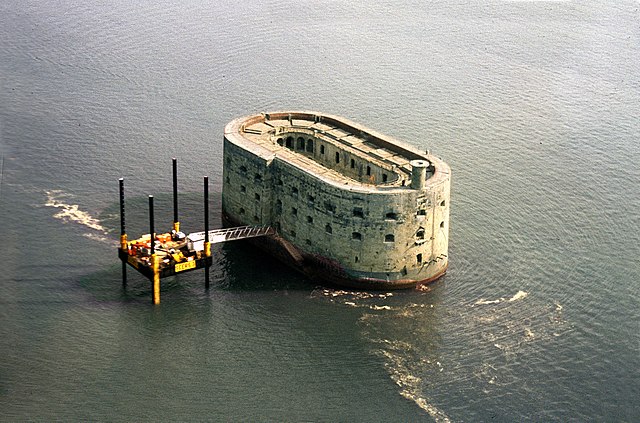 Fort Boyard, pictured in 1989, during refurbishment work with its original access platform already installed. The watchtower has not been rebuilt yet.