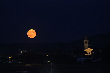 Maria Santissima delle Grazie church with full moon, Albinia, Italy