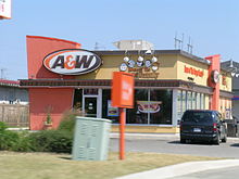 A standalone A&W restaurant with bright orange and yellow exterior in Stratford, Ontario, in 2007 Canadian aandw ne.JPG