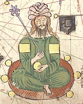 Assis en tailleur, un personnage à longue barbe, coiffé d'un turban blanc, vêtu d'un caftan vert émeraude sans col et portant des brassards dorés tient un sceptre dans la main droite