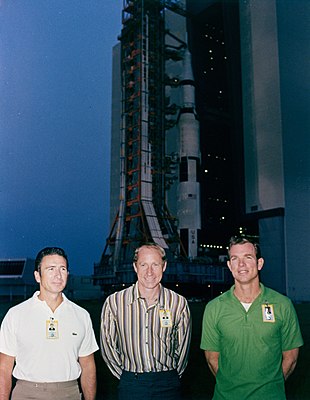 The astronauts pose before the VAB as the Saturn V is rolled out