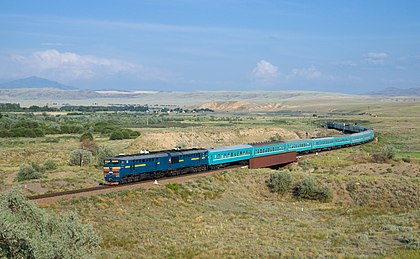 Trem número 22, que liga Qyzylorda e Semei, puxado por uma locomotiva a diesel classe 2TE10U da Companhia Ferroviária Nacional Temir Zholy (KTZ). Foto tirada próximo da estação de Ainabulak, Cazaquistão. (definição 4 364 × 2 694)