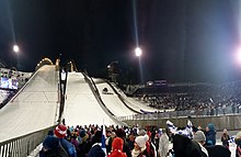 Vorderansicht mit drei Skisprungschanzen.