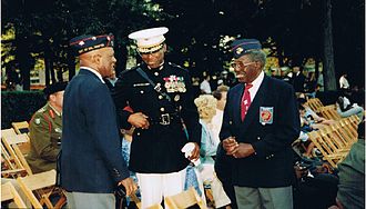 Reuben J. McNair Sr., and a fellow veteran of the Montford Point Marine Association, converses with a present-day African American Marine officer. MPMA Generations.JPG