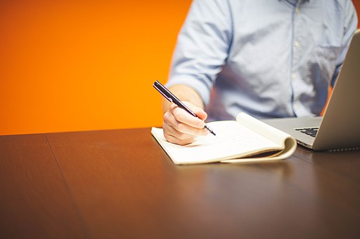 Man writing while using his laptop 1