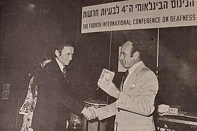 Moshe Shem Tov recebe Dragoljub Vukotić [it], o presidente da Federação Mundial de Surdos, e lhe entrega um presente na Quarta Conferência Internacional sobre Surdez em Bat Yam, 1973.