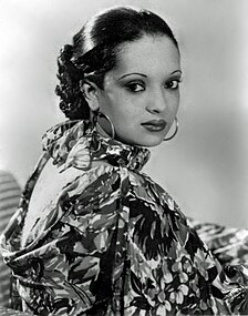 Nina Mae McKinney—one of the first African-American Hollywood actresses—c. 1936, wearing hoop earrings and a floral print ensemble.