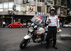 A Syrian traffic police officer in Damascus. Posters and bunting of 2014 Syrian presidential election in Damascus (6).jpg